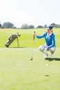 Female golfer watching her ball on putting green