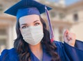 Female Graduate in Cap and Gown Wearing Medical Face Mask