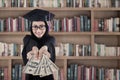 Female graduate holding money at library Royalty Free Stock Photo