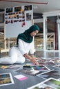 Female graphic designer in hijab checking photographs in office Royalty Free Stock Photo