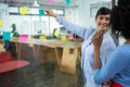 Female graphic designer pointing to the sticky notes on the glass in creative office Royalty Free Stock Photo