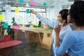 Female graphic designer pointing to the sticky notes on the glass in creative office Royalty Free Stock Photo