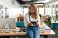 Female graphic designer reviewing photos on digital camera at desk Royalty Free Stock Photo