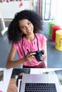 Female graphic designer reviewing photos on digital camera at desk in office Royalty Free Stock Photo