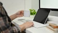 A female graphic designer sipping coffee while working at her desk, typing on keyboard Royalty Free Stock Photo