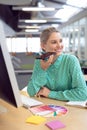 Female graphic designer talking on mobile phone Royalty Free Stock Photo