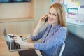 Female graphic designer talking on mobile phone while working in office Royalty Free Stock Photo