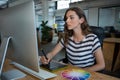 Female graphic designer using graphics tablet at desk