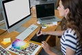 Female graphic designer using graphics tablet at desk Royalty Free Stock Photo