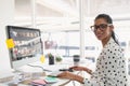 Female graphic designer using graphic tablet at desk in office Royalty Free Stock Photo