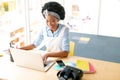 Female graphic designer using graphic tablet and laptop at desk Royalty Free Stock Photo