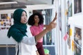 Female graphic designers discussing over photographs in office