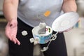 A female in gray t-shirt dropping teacup with teabag sugar cubes and spoon