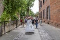 Female guide iwearing a face mask and in historic costume explains to visitors the landmarks of the old town in Sacramento