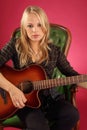 Female guitarist sitting on leather chair