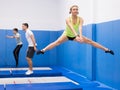 Female gymnast practicing middle split on trampoline
