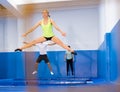 Female gymnast practicing middle split on trampoline