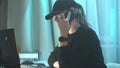 Female hacker working on laptop. Woman work and give a call by cellphone.