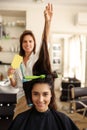 Female hairdresser curls woman`s hair, hairsalon