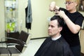 Female hairdresser cuts man hair