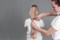 Emale hairdresser hold in hand between fingers lock of blonde hair, comb and scissors closeup. Image of hairdresser trimming ends