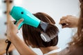 Female hairdresser making hairstyle to brunette girl in beauty salon. Royalty Free Stock Photo