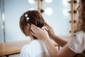 Female hairdresser making hairstyle to brunette girl in beauty salon. Royalty Free Stock Photo