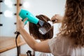 Female hairdresser making hairstyle to brunette girl in beauty salon. Royalty Free Stock Photo