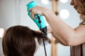 Female hairdresser making hairstyle to brunette girl in beauty salon. Royalty Free Stock Photo