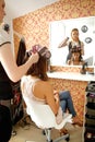 Female hairdresser spraying hairspray in customer's hair