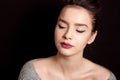 Female hairstyle medium bun with brown hair make-up red lips and black arrow perfect skin