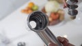 Female hand assembles meat grinder head for providing quality mince frommeat. Electric mincer machine for minced meat