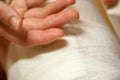 Female hand on a background of a bandaged foot of a patient