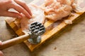 Female hand beat chicken fillet with hammer Royalty Free Stock Photo