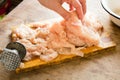 Female hand beat chicken fillet with hammer Royalty Free Stock Photo