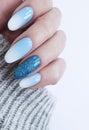 Female hand beautiful fashion blue design ombre acrylic manicure, sweater, winter style Royalty Free Stock Photo