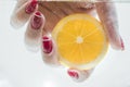 Female hand holding a slice of fresh lemon under water. Royalty Free Stock Photo