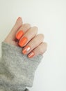 Female hand beautiful orange elegant manicure relax cozy sweater Royalty Free Stock Photo