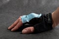 Female hand in bicycle glove black and blue with open fingers close-up on a dark background