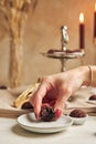 Female hand with a bitten Brazilian Brigadeiro, choco ball decorated with sprinkles