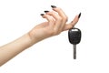 A female hand with a black nails manicure holds a black car key with her fingers. Isolated on white background Royalty Free Stock Photo