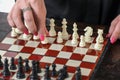 Female hand with bright manicure holds white pawn at beginning of chess game. Women in chess sport Royalty Free Stock Photo