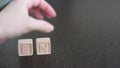 A female hand builds word envy with wooden cubes. Concept