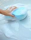 Female hand is cleaning car bonnet with blue sponge Royalty Free Stock Photo