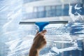 Female hand cleaning dirty glass window with a squeegee Royalty Free Stock Photo