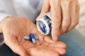 Female hand close up holding a medicine, elderly woman hands with pill on spilling pills out of bottle Royalty Free Stock Photo