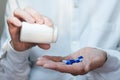 Female hand close up holding a medicine, elderly woman hands with pill on spilling pills out of bottle Royalty Free Stock Photo