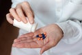 Female hand close up holding a medicine, elderly woman hands with pill on spilling pills out of bottle Royalty Free Stock Photo