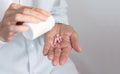 Female hand close up holding a medicine, elderly woman hands with pill on spilling pills out of bottle Royalty Free Stock Photo