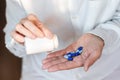 Female hand close up holding a medicine, elderly woman hands with pill on spilling pills out of bottle Royalty Free Stock Photo